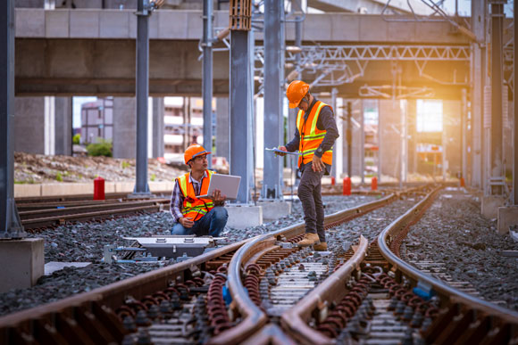 Two rail workers in high visibility clothing perform safety critical rail assessment.